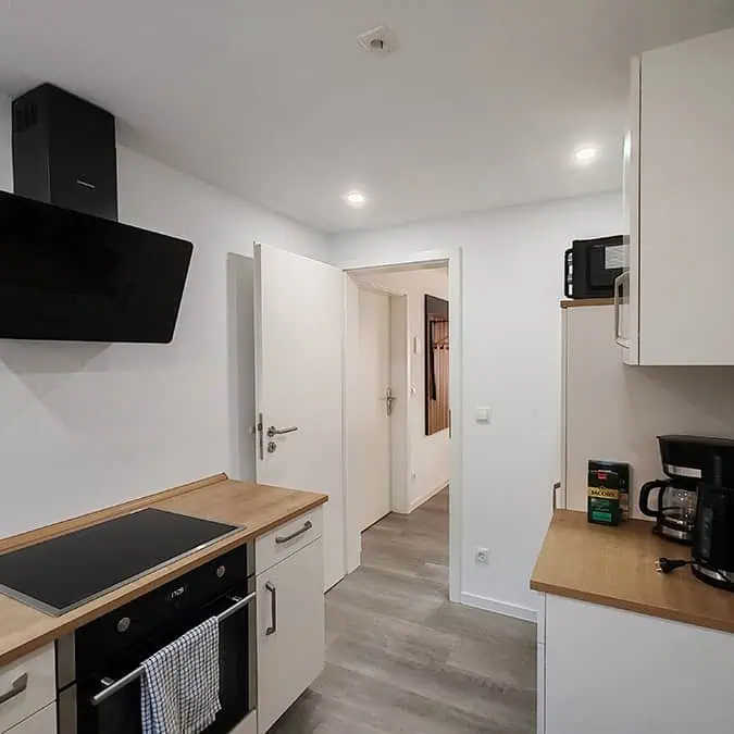 Küche mit einem modernen Herd, Dunstabzugshaube und Küchenschränken in neutralen Farben.